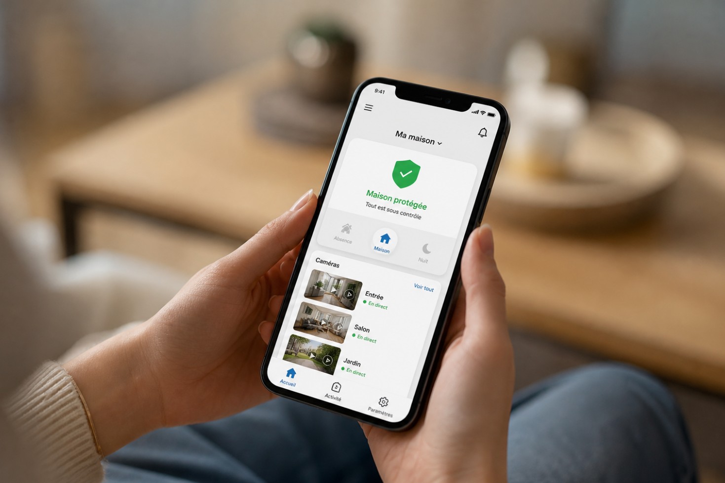 Mains tenant un smartphone affichant une application de sécurité domestique